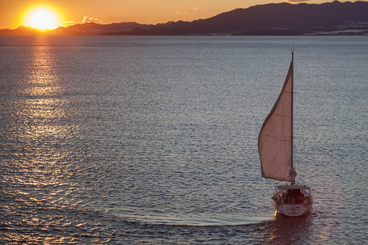 El velero Jaloke navegando al atardecer frente a la costa de Murcia