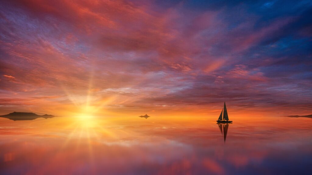 Velero en el horizonte bajo un atardecer espectacular