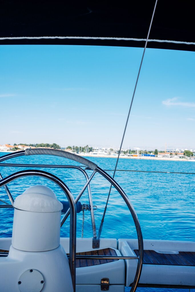 Al timón de un velero en aguas turquesas, con el mar por delante